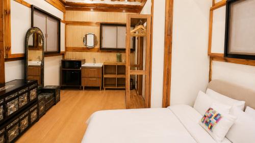 a small room with a bed and a kitchen at HAEMIL Hanok 해밀한옥 in Seoul