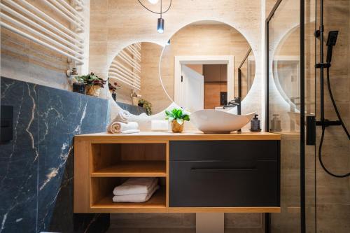 a bathroom with a sink and a mirror at Global Apartments Katowice in Katowice