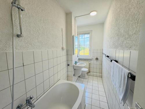 a white bathroom with a tub and a toilet at FeWo Einetal 3 im schönen Ostharz in Harzgerode