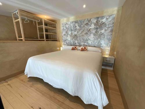 a bedroom with a white bed with two teddy bears on it at Can Padrosa Mini loft 3 in Riumors