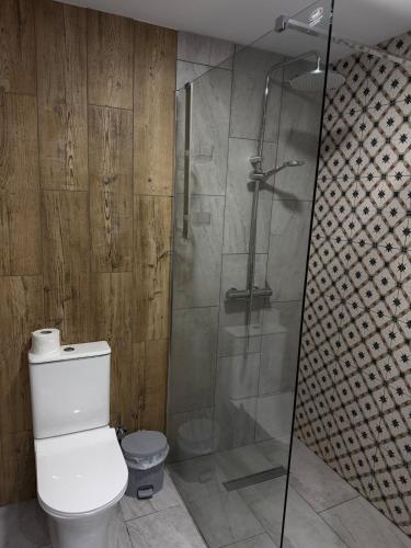 a bathroom with a toilet and a glass shower at Casa Clara Pool Strand Meerblick in Khlorakas