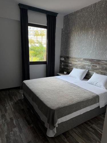 a bedroom with a large bed and a window at Casa Clara Pool Strand Meerblick in Khlorakas