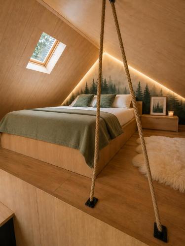 a bedroom with a hanging bed in a attic at The Landscape Barn Homes in Râşnov