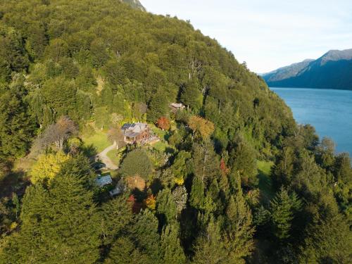 an aerial view of a house on a hill next to a lake at Barraco Lodge in Puelo