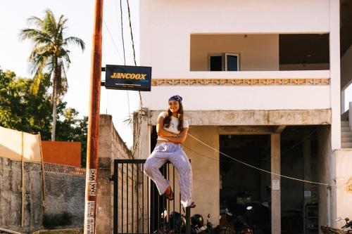 a woman is on a rope in front of a building at Jancoox Hostel in Kuta Lombok