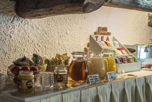 a table with jars of tea and fruits on it at Hotel Colle Etrusco Salivolpi in Castellina in Chianti