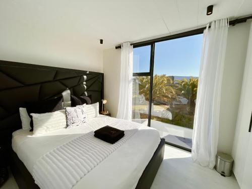 a bedroom with a large bed and a large window at 42 on Kavango Unit 17 in Khomas Region