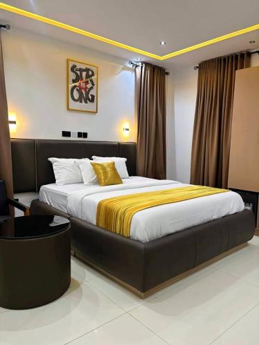 a bedroom with a large bed with a yellow blanket at Ciamo Hotel in Ikeja