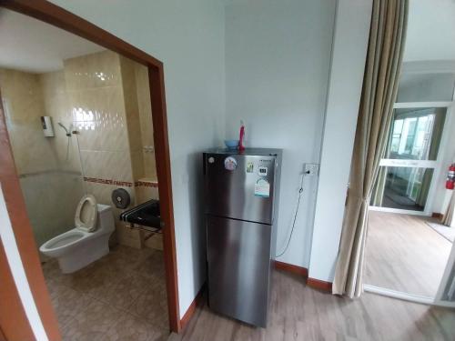 a kitchen with a refrigerator and a toilet in a room at Open Kitchen Chiang Rai in Chiang Rai