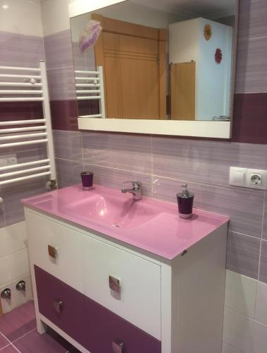 a bathroom with a pink sink and a mirror at La magia de Benjamín in Oviedo