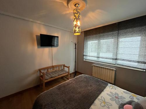 a bedroom with a bed and a television and a lamp at La magia de Benjamín in Oviedo