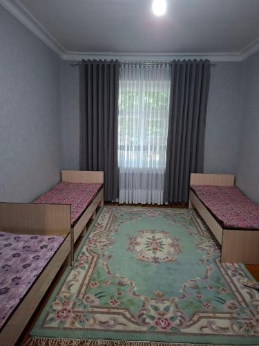 a room with two beds and a rug at Flat in mountains in Yangiobod