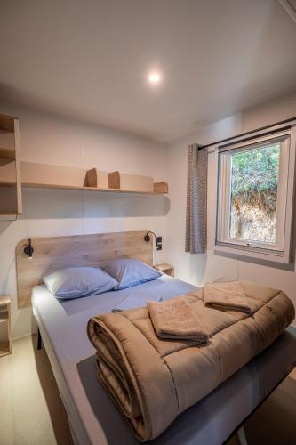 a bedroom with a large bed and a window at Camping Milella in Propriano