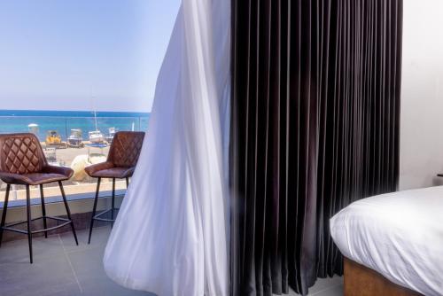 a bedroom with a bed and a view of the ocean at H34 Boutique Hotel & Spa by the sea of Nahariya in Nahariyya