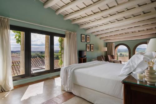 a bedroom with a large bed and large windows at Encís d'Empordà -Adults Only- in Casavells