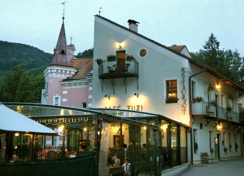 a building with a restaurant in front of a castle at Penzión Zuzi in Trenčianske Teplice
