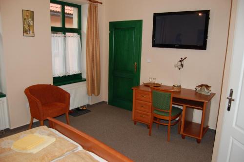 a room with a desk and a green door at Penzión Zuzi in Trenčianske Teplice