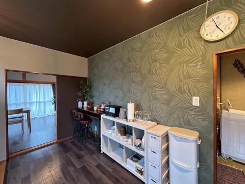 a room with a wall with a clock on it at Kawazu Sakura-so in Kawazu