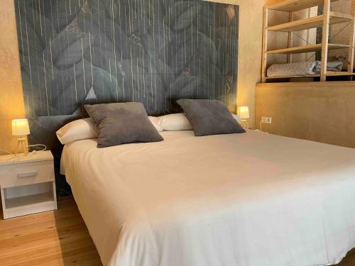 a bedroom with a large white bed with two pillows at Can Padrosa Mini Loft 2 in Riumors