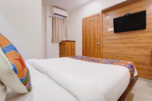 a bedroom with a bed and a flat screen tv at FabHotel Shaurya Inn MIDC in Ghansoli