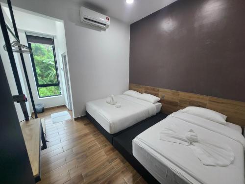 a hotel room with two beds and a window at Hotel O Rosegold Garden in Kuantan