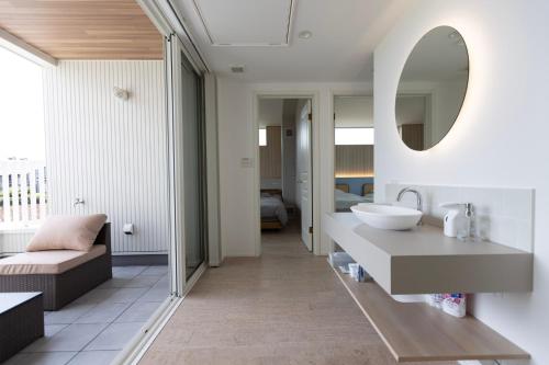 a bathroom with a sink and a mirror at RYOAN Ichinomiya in Ichinomiya