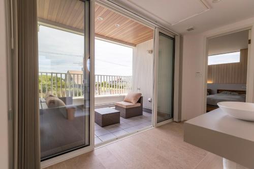 a bathroom with a large glass door leading to a balcony at RYOAN Ichinomiya in Ichinomiya