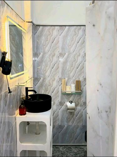 a bathroom with a black sink and a stone wall at Mahika Guest House Siquijor in San Juan