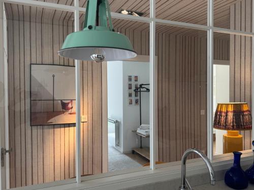a kitchen with a green light hanging over a sink at Apartamento Loiola in Azpeitia