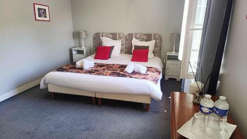 a bedroom with a large bed with red pillows at Moulin De Bacchus - Châteaux de la Loire in Chançay