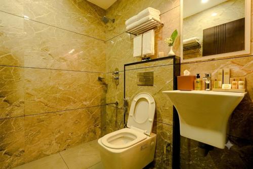 ein Badezimmer mit Toilette und Waschbecken in der Unterkunft Time Square Inn in Erāttupetta