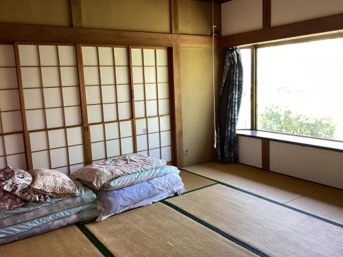 a room with two beds and a window at いちご荘 in Ichihara