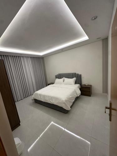 a bedroom with a white bed and a white ceiling at شقق تأجير يومي in Musaylah