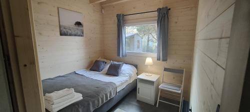 a small bedroom with a bed and a window at Odpoczynkowo in Orle
