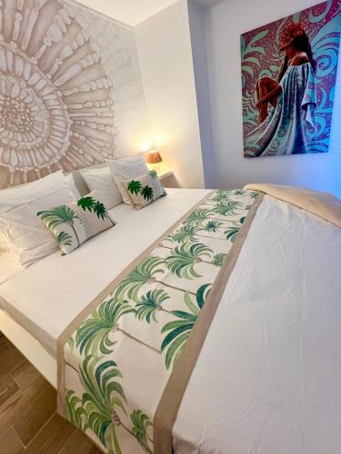 a bed in a room with a painting on the wall at Centre Ville Fare Vairahi in Uturoa
