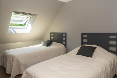 two beds in a room with a window at l atelier des etoiles in Haybes
