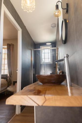 a bathroom with a wooden sink in a room at l atelier des etoiles in Haybes