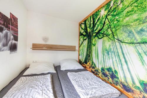 a bedroom with two beds and a large painting on the wall at Ferienhaus 35 in Zadelsdorf