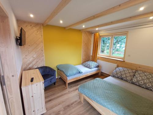 a small room with two beds and a window at Domek u Szwajnosów in Ciche