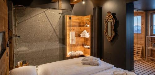 a bathroom with a shower and a bed with towels at DolomitiBel Siberiana 2 SILVER in Braz