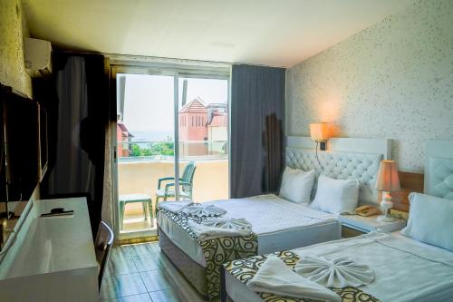 a hotel room with two beds and a balcony at CLUB MONTE CARLO HoTEL in Alanya