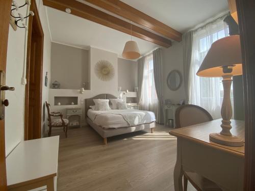 a bedroom with a bed and a table with a lamp at La Maison du Poelon in Labarthe-sur-Lèze