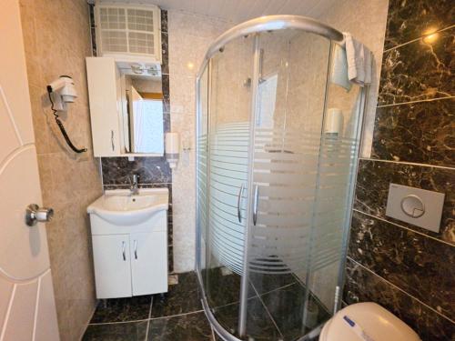 a bathroom with a shower and a toilet and a sink at CLUB MONTE CARLO HoTEL in Alanya