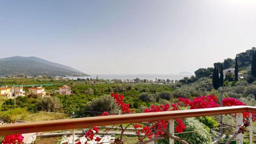 a view from a balcony with red flowers at Epidavros Villas - Gardenia Garden Retreat with Shared Pool in Nea Epidavros