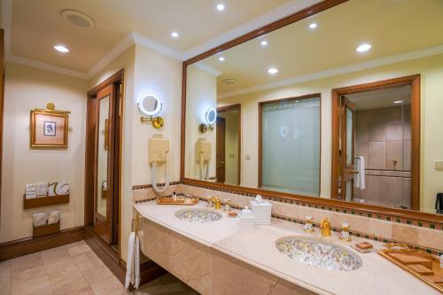 a bathroom with two sinks and a large mirror at Pearl Continental Hotel, Lahore in Lahore
