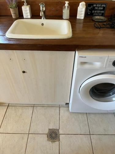 a kitchen with a sink and a washing machine at Paros Sunset Villas PSV & PSV2 in Parikia