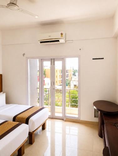 a hotel room with two beds and a window at Luxe By Lotels in Chennai