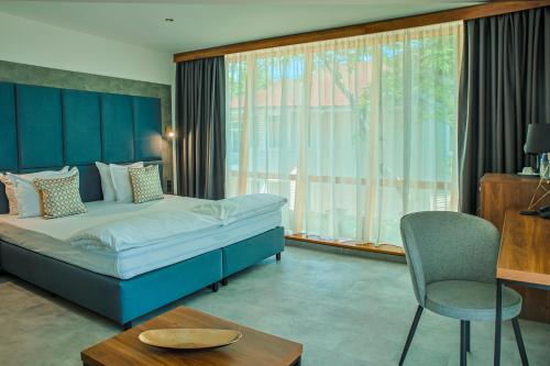 a bedroom with a bed and a chair and a table at Hotel Trezor in Varna City