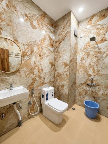 a bathroom with a toilet and a sink at Vortex Suites in Guwahati