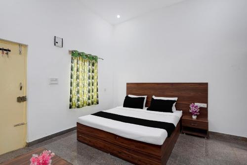 a bedroom with a large bed with a wooden headboard at Hotel O B.N.R. INN in Bangalore